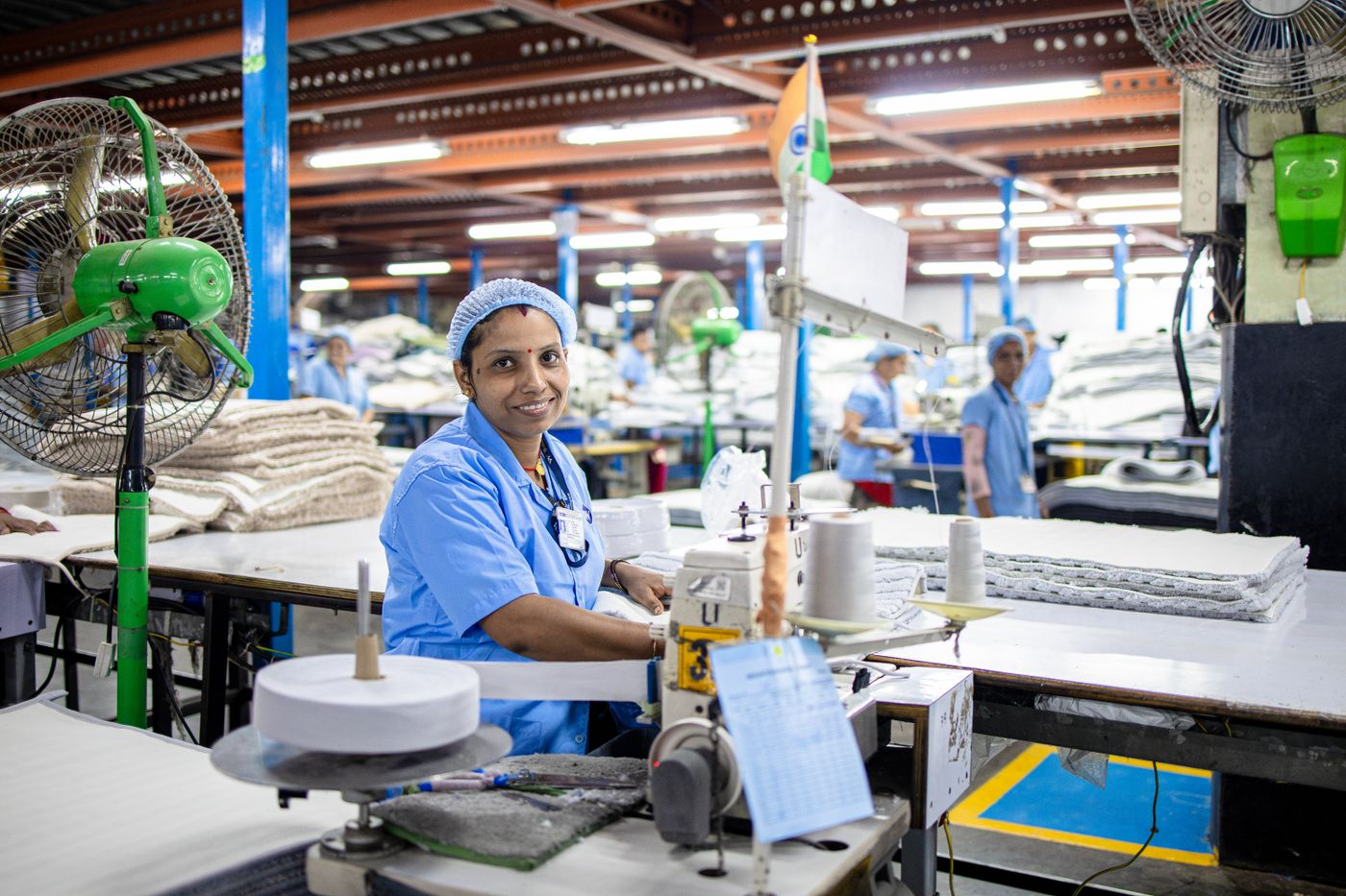 Une ouvrière au travail sur une machine à coudre dans un atelier textile