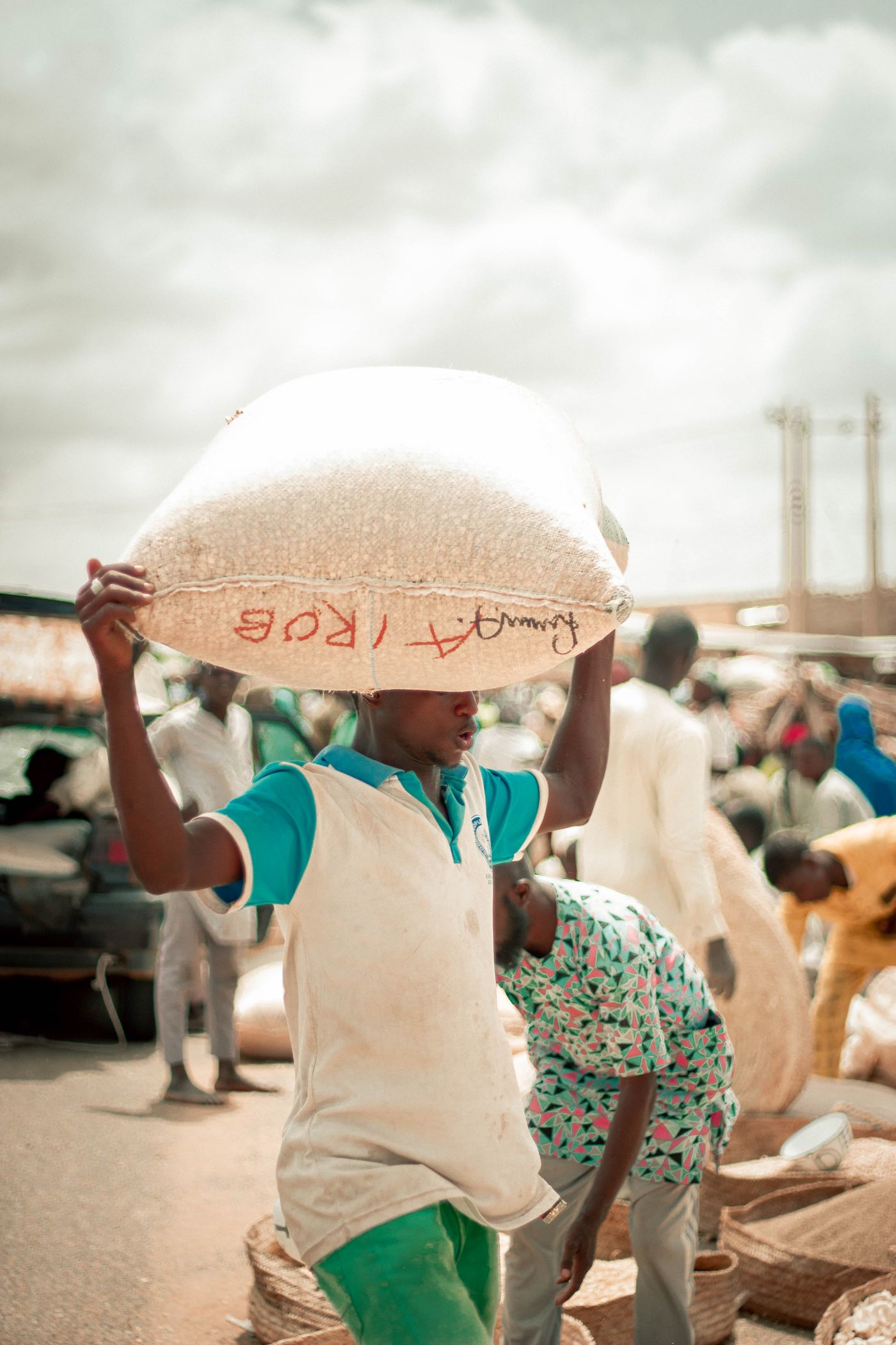 Un commerçant portant un sac de marchandise sur l’épaule dans un marché de gros